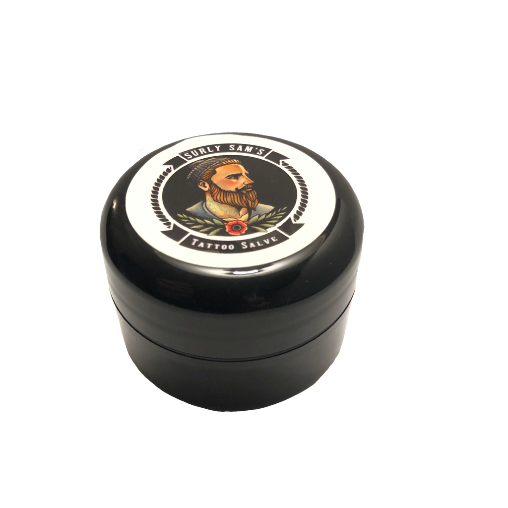 Surly Sam’s Tattoo Care Salve 1/2 ounce  Surly Sam's is premium tattoo care made from natural ingredients to cut inflammation, speed healing, ward off germs and keep your ink fresh! Used before, during and after the tattoo process, Surly Sam’s Tattoo Salve protects your art investment. Used and loved by tattoo artists, doesn't clog needles or remove stencil.